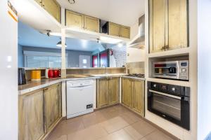 滨海布朗22 couchages centre de Brem的厨房配有木制橱柜和白色家电