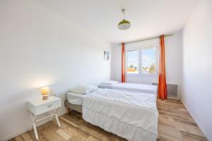 滨海布朗22 couchages centre de Brem的有两张床和一扇窗户的卧室