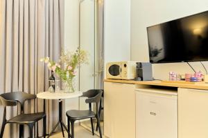 um quarto com uma mesa com cadeiras e uma televisão em H7 TLV em Tel Aviv