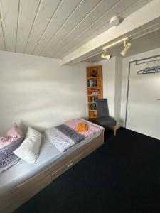 a small room with a bed and a chair at Large Room Near The train station and highway in Schnaittach