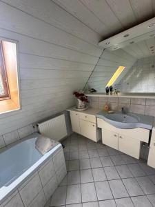 a bathroom with a tub and a sink at Large Room Near The train station and highway in Schnaittach