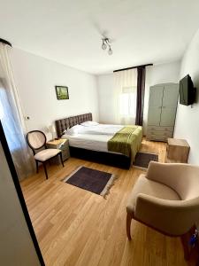 ein Schlafzimmer mit einem Bett, einer Couch und einem Sessel in der Unterkunft Pensiunea Ioana in Sadová