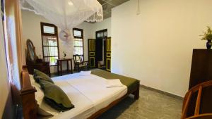 ein Schlafzimmer mit einem Bett in einem Zimmer in der Unterkunft Gurugedara Heritage Talalla in Talalla