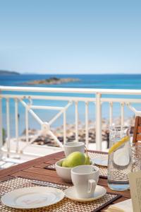 - une table avec des assiettes, des tasses et un bol de fruits dans l'établissement Nostos - Psili Ammos Appartments, à Psili Ammos