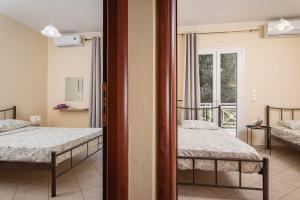 une chambre avec deux lits et un miroir dans l'établissement Nostos - Psili Ammos Appartments, à Psili Ammos