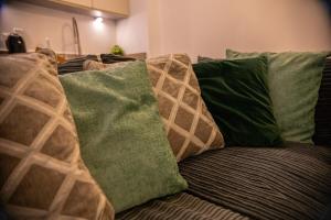 eine Couch mit grünen und braunen Kissen drauf in der Unterkunft Stylish Kent apartment in Maidstone + 41 Fotos