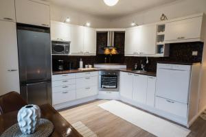 eine Küche mit weißen Schränken und Geräten aus Edelstahl in der Unterkunft Renovated 60m2 flat & free parking, balcony, Wifi in Pori