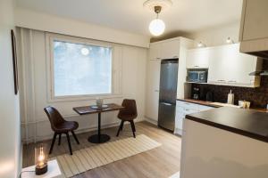 eine Küche mit Tisch und Stühlen und einem Kühlschrank in der Unterkunft Renovated 60m2 flat & free parking, balcony, Wifi in Pori + 9 Fotos