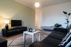 ein Wohnzimmer mit Sofa und Fernseher in der Unterkunft Renovated 60m2 flat & free parking, balcony, Wifi in Pori