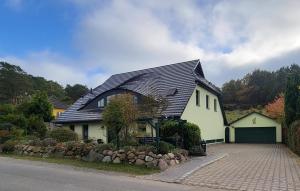 a white house with a black roof and a driveway at Ferienwohnung Flieder - ruhig und tierfreundlich in Mariendorf +10 photos
