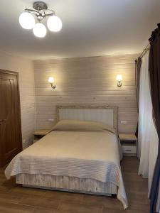 a bedroom with a large bed with two lights on it at Котедж GLORIA будинок повністю in Yaremche
