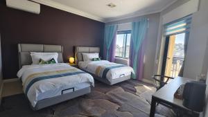 a bedroom with two beds and a large window at Sunny Ocean View Retreat in Perth