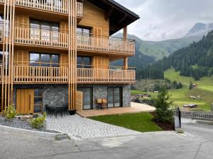 a large building with a balcony on the side of it at Almrausch Lech Apartments in Lech am Arlberg
