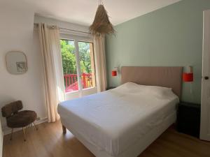 a bedroom with a white bed and a window at Les rives enchantées in Courçay