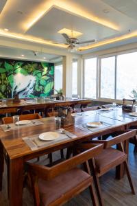 a large dining room with wooden tables and chairs at Heryk Hillview Hotel in Dharamshala