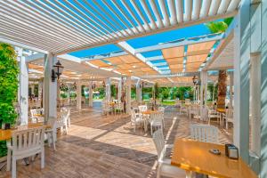 a patio with tables and chairs under awning at Serenis Hotel in Side