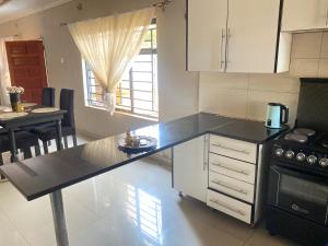 a kitchen with a black counter top and a table at Executive house in Lusaka