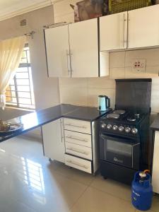 a kitchen with a black stove and white cabinets at Executive house in Lusaka