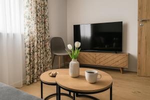 ein Wohnzimmer mit einer Vase mit Blumen auf einem Tisch in der Unterkunft Bezpieczna Przystań in Frombork