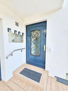 Una puerta azul con una ventana en una habitación en Basilisk Homes - in Grenzach-Wyhlen bei Basel - 4 x Moderne Fewos je 1bis2, 1bis4 oder 1bis6 Pers mit Küche und Balkon oder Terrasse - Parkplätze vorhanden, en Grenzach-Wyhlen 97 fotos más
