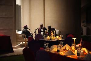 un grupo de personas disfrazadas sentadas alrededor de una mesa en Dana Beach Resort, en Al Sharqiyah