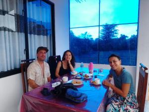 un grupo de personas sentadas alrededor de una mesa en Sigiri Rock View Lodge, en Sigiriya