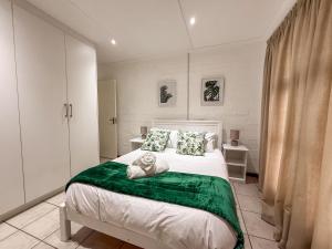 Gulls Nest في هيرمانوس: غرفة نوم بسرير كبير مع بطانية خضراء