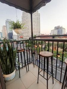 a balcony with two stools and a potted plant at Lucky Motel - Self Checkin in Hanoi