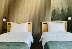 two beds sitting next to each other in a bedroom at Апарт-готель "Модерн 24" in Netishyn