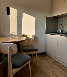a small kitchen with a table and chairs in a room at Апарт-готель "Модерн 24" in Netishyn +28 photos