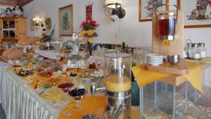 a long table with food and drinks on it at Gästehaus Reichart in Scheidegg