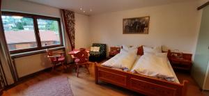 a bedroom with a bed and a table and a window at Gästehaus Reichart in Scheidegg