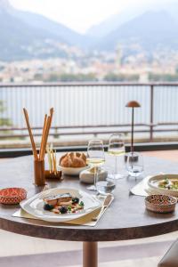 マルグラーテにあるHotel Griso Collectionの食べ物の皿とワインのグラスが置かれたテーブル