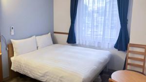 Postel nebo postele na pokoji v ubytování Toyoko Inn Hokkaido Tokachi Obihiro Ekimae