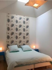 a bedroom with a bed with a wall with pine cones at Gites Gayet in Fours +17 photos