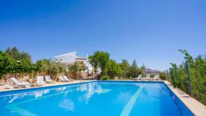 a large swimming pool with lounge chairs and trees at Cortijo El Álamo 1 Vélez Blanco by Ruralidays in Vélez Blanco