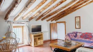 a living room with a couch and a tv at Cortijo El Álamo 1 Vélez Blanco by Ruralidays in Vélez Blanco