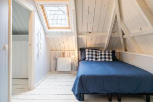 a bedroom with a blue bed in a attic at De Friese Wouden in Suameer