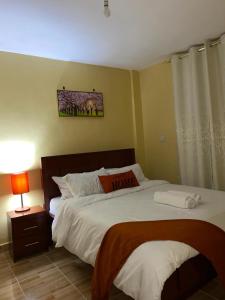 Taste of Home by Chel في ناكورو: غرفة نوم بسرير كبير ونافذة