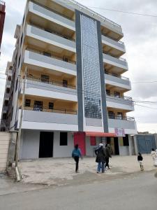 Taste of Home by Chel في ناكورو: مجموعة من الأشخاص يسيرون أمام مبنى