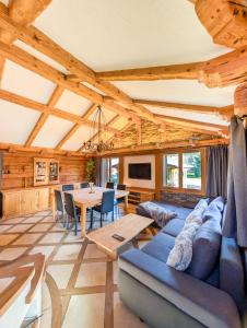 Una sala de estar con un sofá azul y una mesa. en Appt de charme dans chalet - liberté & nature, en Chesières