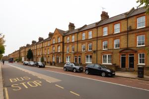 a bus stop sign on the side of a street at Superb 2 Bed Apartment in Battersea in London