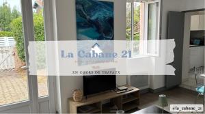 ein Wohnzimmer mit einem TV auf dem Tisch in der Unterkunft La Cabane 21, Andernos-Les-Bains in Andernos-les-Bains