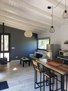 eine Küche und ein Wohnzimmer mit Tisch und Stühlen in der Unterkunft Cabaña Panpachay Villa Giardino in Villa Giardino