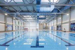 a large swimming pool with blue water at Orca Apartman in Jagodina