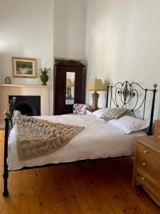 a large bed in a bedroom with a fireplace at The Gilded Hare in Moonta in Moonta