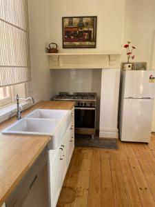 a kitchen with a white sink and a refrigerator at The Gilded Hare in Moonta in Moonta