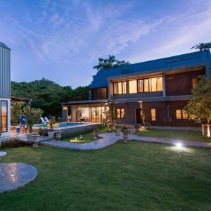 a large house with a lawn in front of it at Cosy Pool Villa at Khaoyai in Nong Nam Daeng