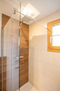 a shower with a glass door in a bathroom at Reste Fidèle Duplex in Fiesch +12 photos