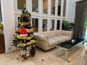 ein Wohnzimmer mit einem Weihnachtsbaum und einer Couch in der Unterkunft 25P Enchanting Bungalow Retreat - Mystical Garden,Petaling Jaya by Verano in Petaling Jaya